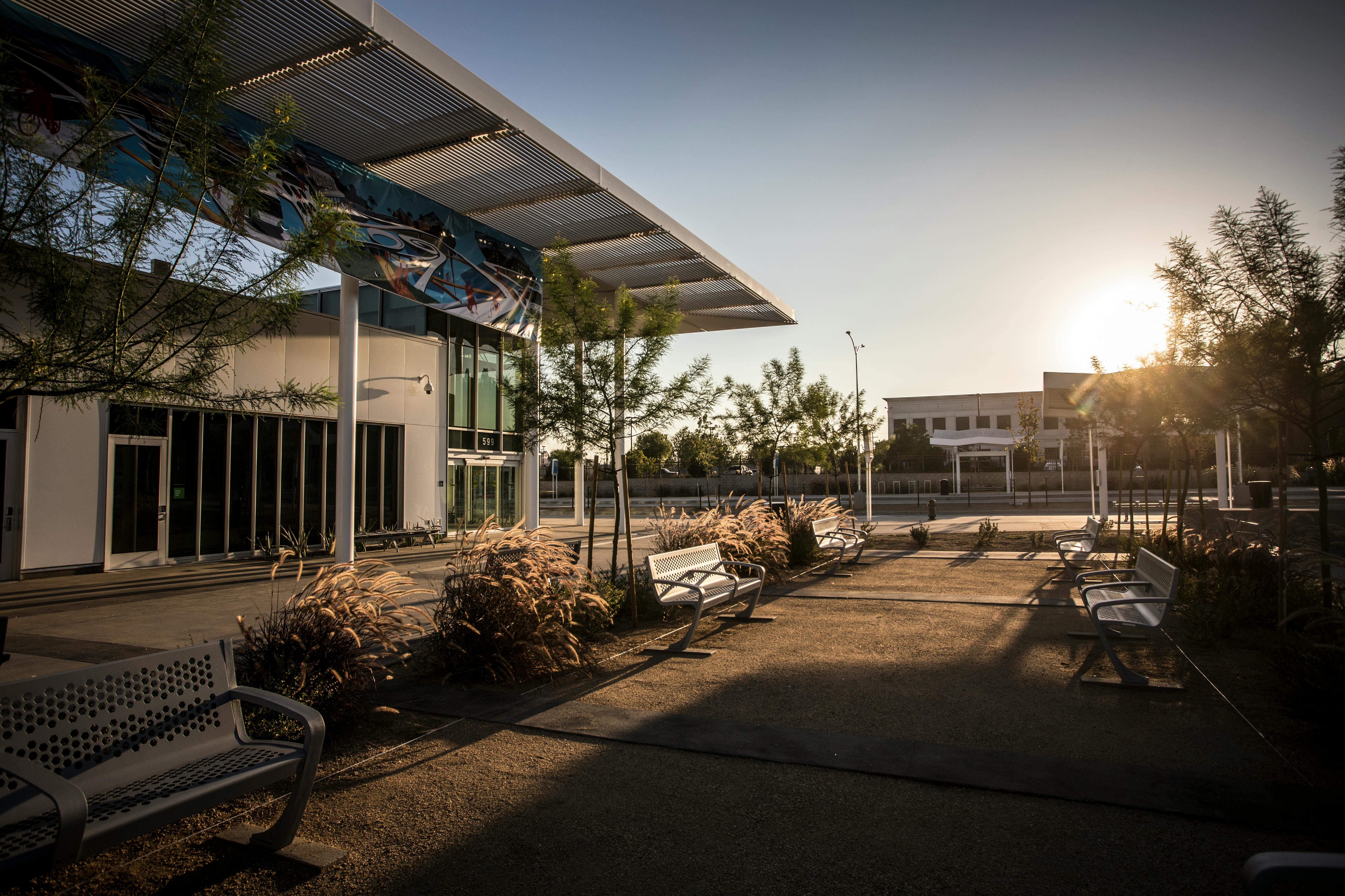 outside a transit station with benches and trees