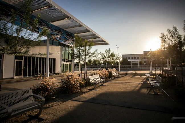 outside a transit station with benches and trees