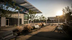 outside a transit station with benches and trees
