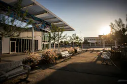 outside a transit station with benches and trees outside a transit station with benches and trees