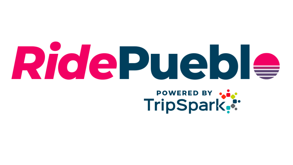The RidePueblo logo on a transparent background. 'Ride' appears in bold red lettering and 'Pueblo' in dark teal, with a stylized sunset icon replacing the letter 'o' &mdash; consisting of a pink semicircle over horizontal red and blue stripes. Below reads 'Powered by TripSpark' with the TripSpark logo, a cluster of colorful dots.