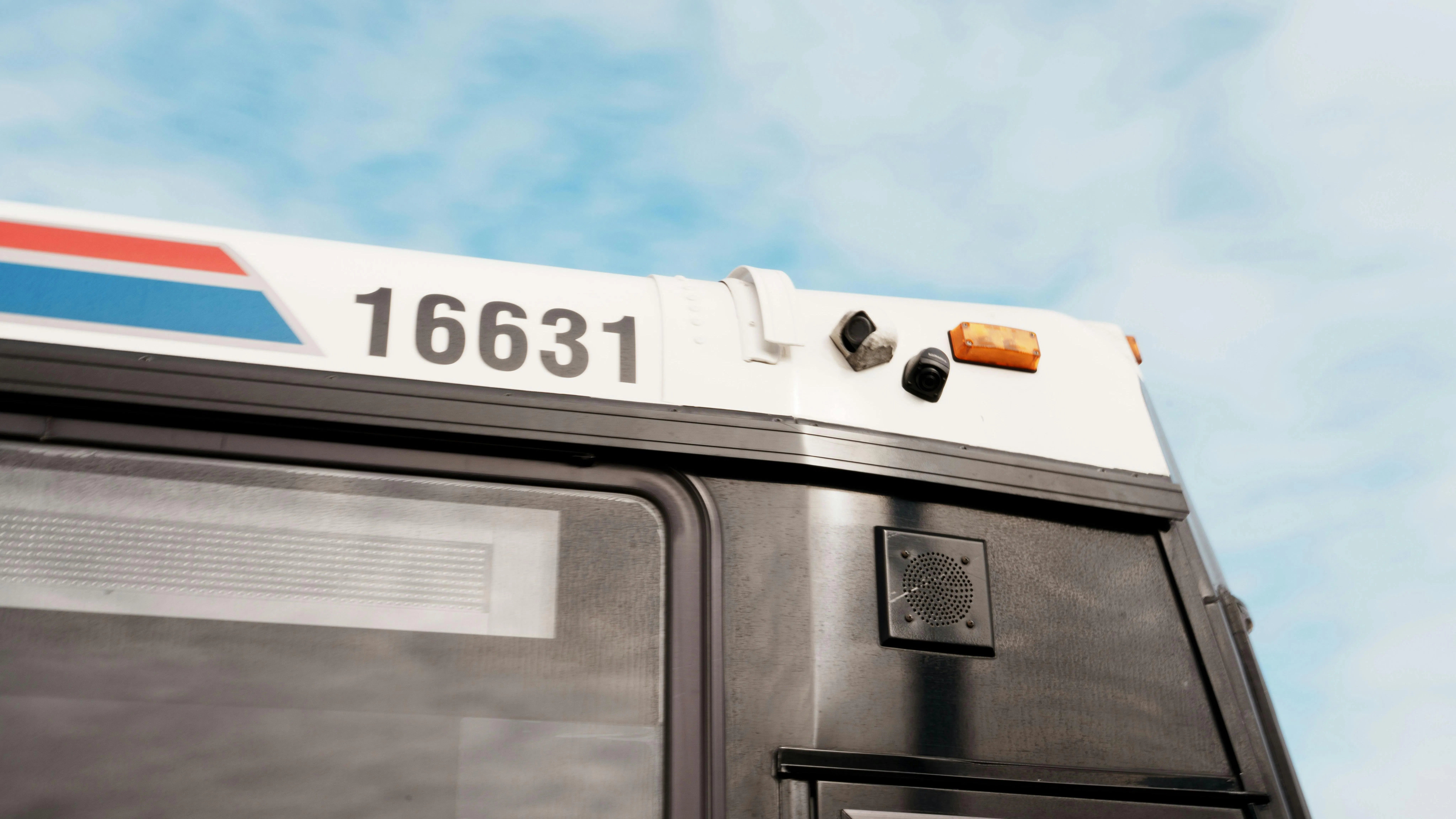 An exterior view of the upper front corner of Coach USA bus No. 16631, showing a small camera mounted near the roofline beside an amber clearance light. An exterior view of the upper front corner of Coach USA bus No. 16631, showing a small camera mounted near the roofline beside an amber clearance light.