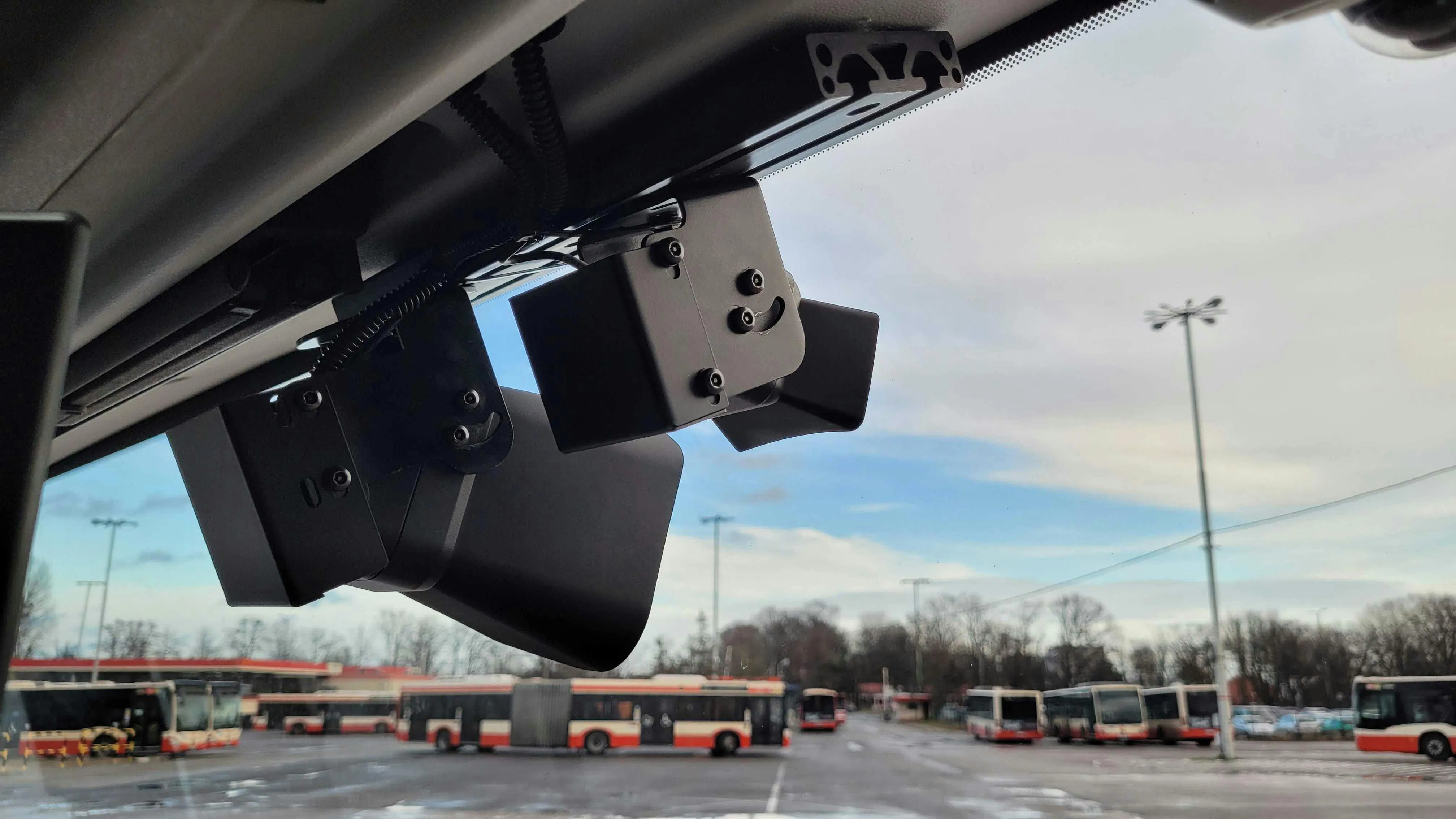 An exterior view of the upper front corner of Coach USA bus No. 16631, showing a small camera mounted near the roofline beside an amber clearance light.
