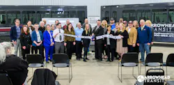 people stand in a line in front of two cutaway buses to cut a ribbon people stand in a line in front of two cutaway buses to cut a ribbon