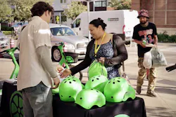 A person picks up a free helmet at an event celebrating the completion of a safety project in Beacon Hill. A person picks up a free helmet at an event celebrating the completion of a safety project in Beacon Hill.