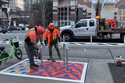 Workers install bike racks on a colorfully painted corral in front of the Seattle Art Museum. Workers install bike racks on a colorfully painted corral in front of the Seattle Art Museum.