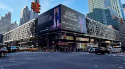 The exterior of the Port Authority Bus Terminal in Midtown Manhattan, viewed from street level at the intersection of Eighth Avenue and 42nd Street, with yellow taxis and pedestrians visible along the sidewalk.