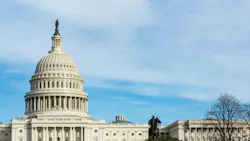 The dome of the United States Capitol against a blue sky with light clouds, with an American flag flying below the dome and an equestrian statue visible at right. The dome of the United States Capitol against a blue sky with light clouds, with an American flag flying below the dome and an equestrian statue visible at right.