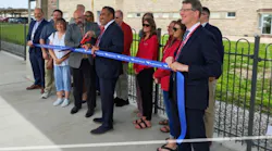 a group of people cut a ribbon on the Ottumwa station platform