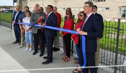 a group of people cut a ribbon on the Ottumwa station platform a group of people cut a ribbon on the Ottumwa station platform