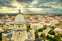 Aerial view of the Illinois State Capitol dome and Springfield skyline under a dramatic sunset Aerial view of the Illinois State Capitol dome and Springfield skyline under a dramatic sunset