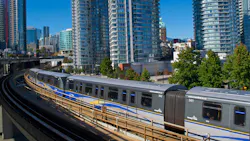 A TransLink SkyTrain traveling on an elevated guideway through downtown Vancouver. A TransLink SkyTrain traveling on an elevated guideway through downtown Vancouver.