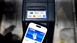 A smartphone displaying a digital Clipper transit card with a $2.95 balance is held up to a contactless fare reader showing Apple Pay, Google Pay, Visa, Mastercard, Discover and American Express acceptance logos. A smartphone displaying a digital Clipper transit card with a $2.95 balance is held up to a contactless fare reader showing Apple Pay, Google Pay, Visa, Mastercard, Discover and American Express acceptance logos.