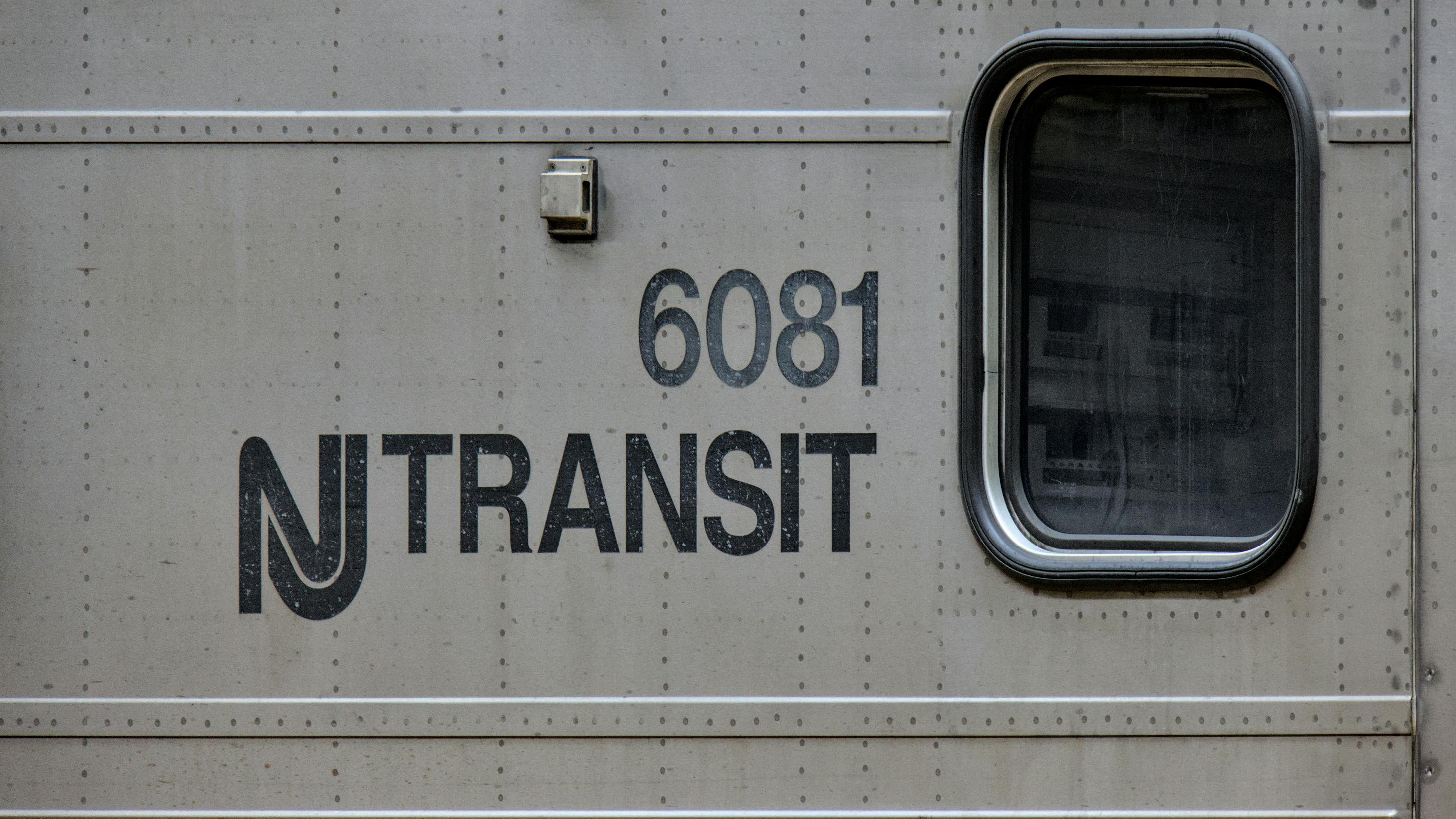 New Jersey Transit logo next to window on a commuter train car numbered 6081.