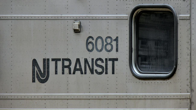 New Jersey Transit logo next to window on a commuter train car numbered 6081.