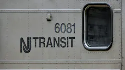 New Jersey Transit logo next to window on a commuter train car numbered 6081. New Jersey Transit logo next to window on a commuter train car numbered 6081.