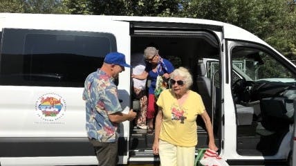 Senior citizens getting out of an Orange County Transportation Authority (OCTA) van as part of the OCTA Senior Mobility Program.