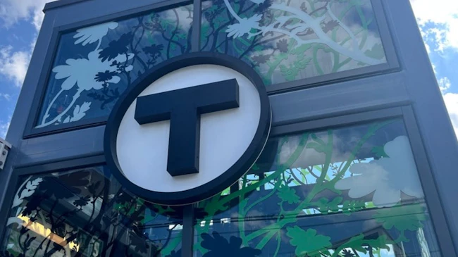 The MBTA T logo shows on a glass station column.