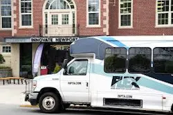 A Rhode Island Public Transit Authority on-demand microtransit van parked in front of the Innovate Newport building in Newport, R.I.