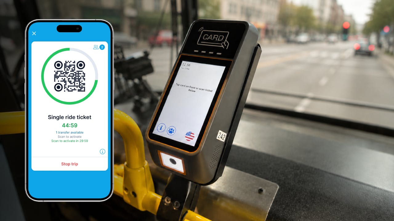mobile phone with valid ticketing on screen to the left of the fare validator box on a bus