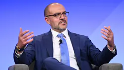 Mark G. Bathrick speaks with his hands as a panelist on stage at the APTA Mobility conference