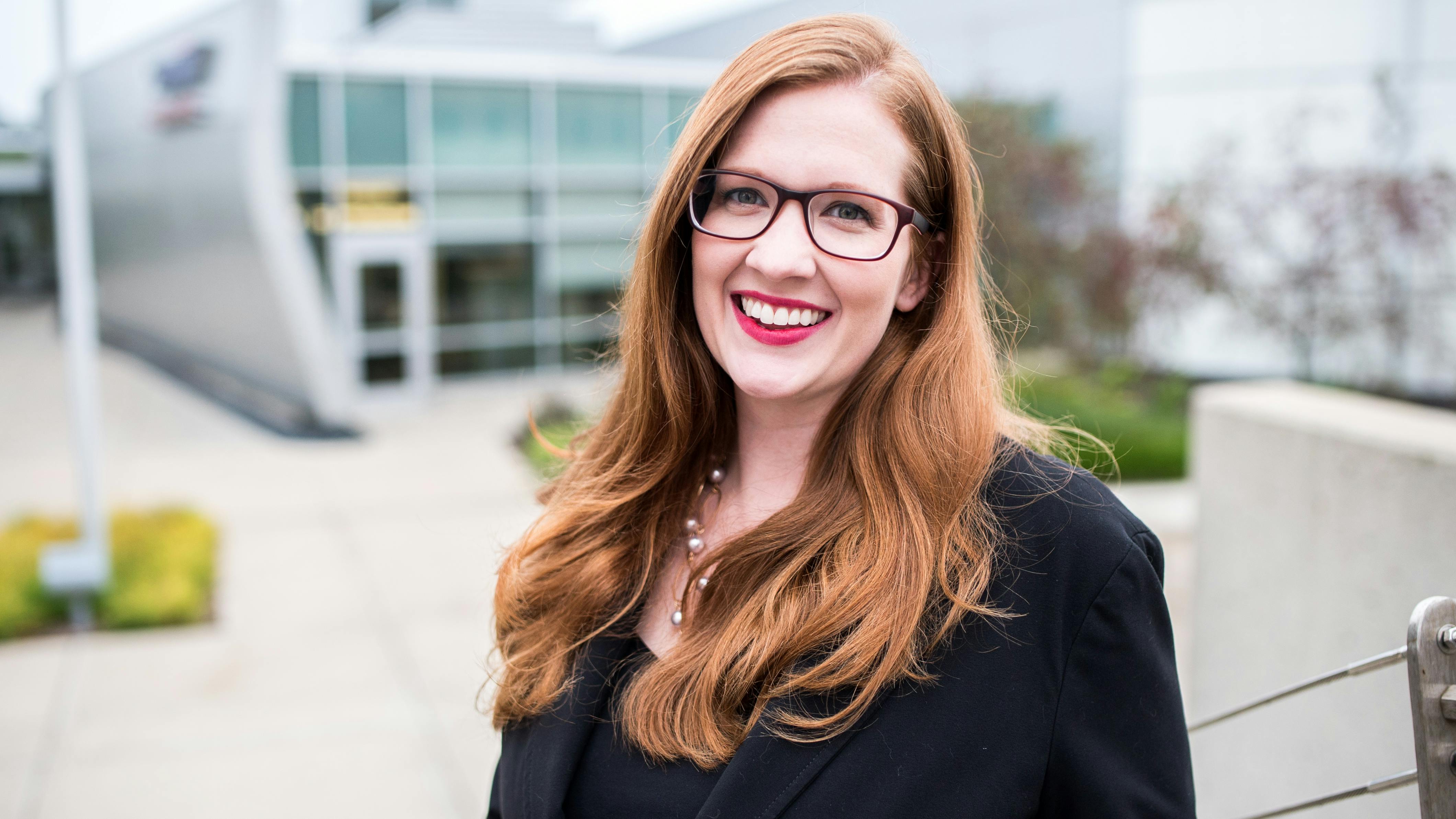 Whitney D. Ehresman stands in front of a blurred outdoor setting on ACT's campus.