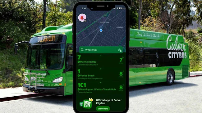A promotional composite image showing a smartphone displaying the official Culver CityBus transit app with real-time route arrivals for routes 7, 1, and 1C1, superimposed in front of a green Culver CityBus New Flyer electric bus parked outdoors, with the tagline 'Doing Our Share for Clean Air' visible on the bus exterior.