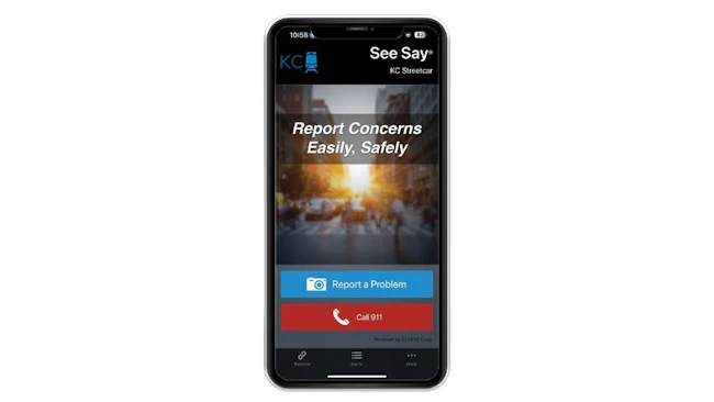 A smartphone mockup displaying the KC Streetcar's See Say safety reporting app, featuring the tagline 'Report Concerns Easily, Safely' and two call-to-action buttons &mdash; a blue 'Report a Problem' button and a red 'Call 911' button &mdash; powered by ELERTS Corp.