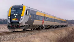 VIA Rail Canada Siemens Venture trainset number 2302 in the agency's gray and yellow livery with a Canadian maple leaf accent, traveling along a rural track through a winter landscape of dormant brush and overcast skies.