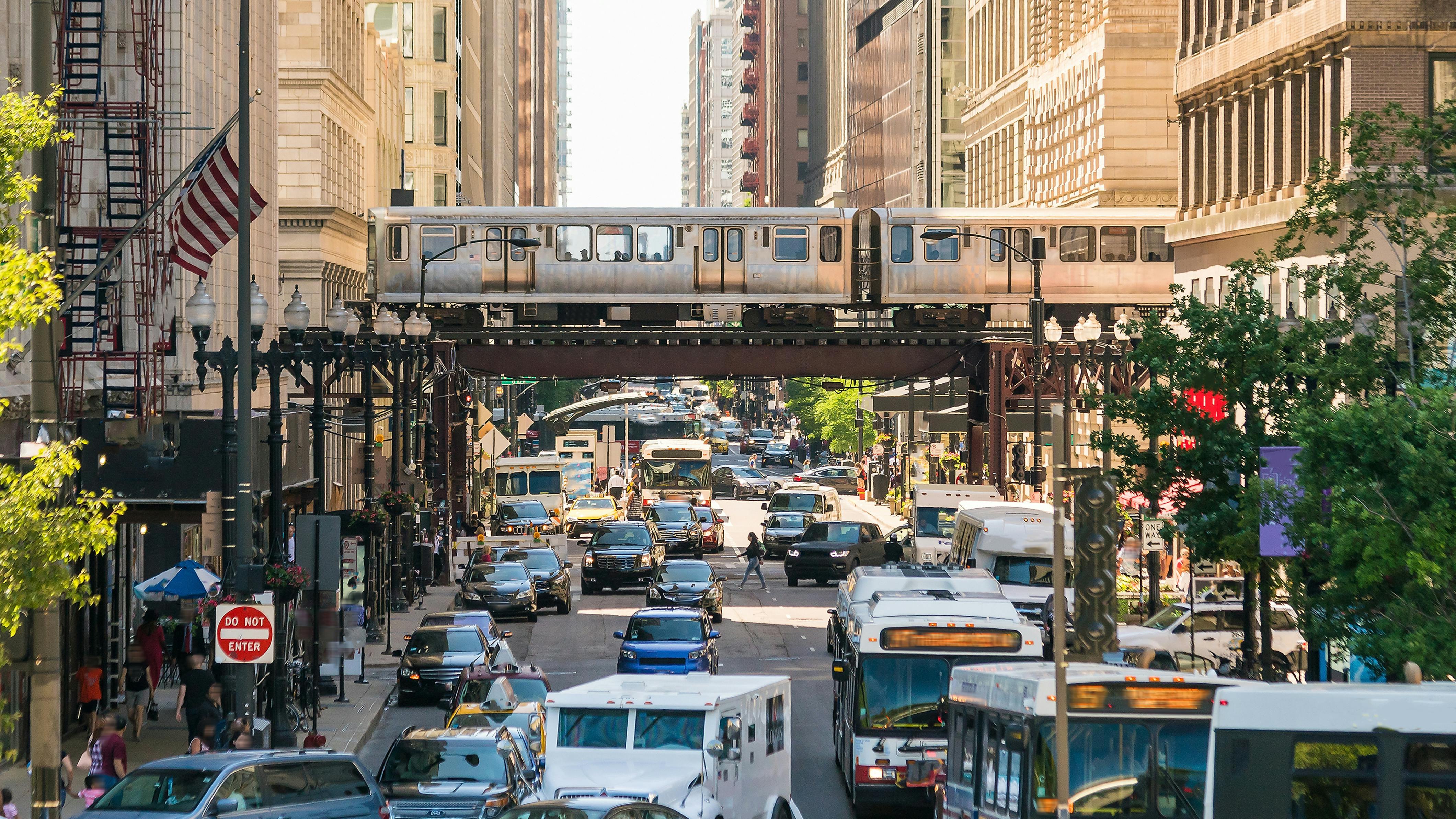 Traffic in downtown Chicago with people, train, car and bus