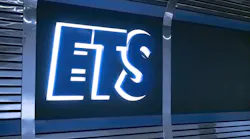 An illuminated blue and white Edmonton Transit Service 'ETS' logo sign mounted on a dark reflective metal panel.