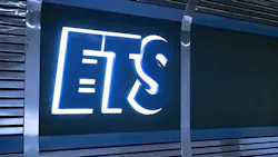An illuminated blue and white Edmonton Transit Service 'ETS' logo sign mounted on a dark reflective metal panel.