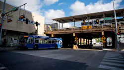 A blue Pace suburban bus stops beneath an elevated CTA rail line at the intersection of South Boulevard and Circle Avenue in Oak Park, Ill., with a '14 FT 0 IN' clearance sign visible under the bridge and traffic signals overhead.