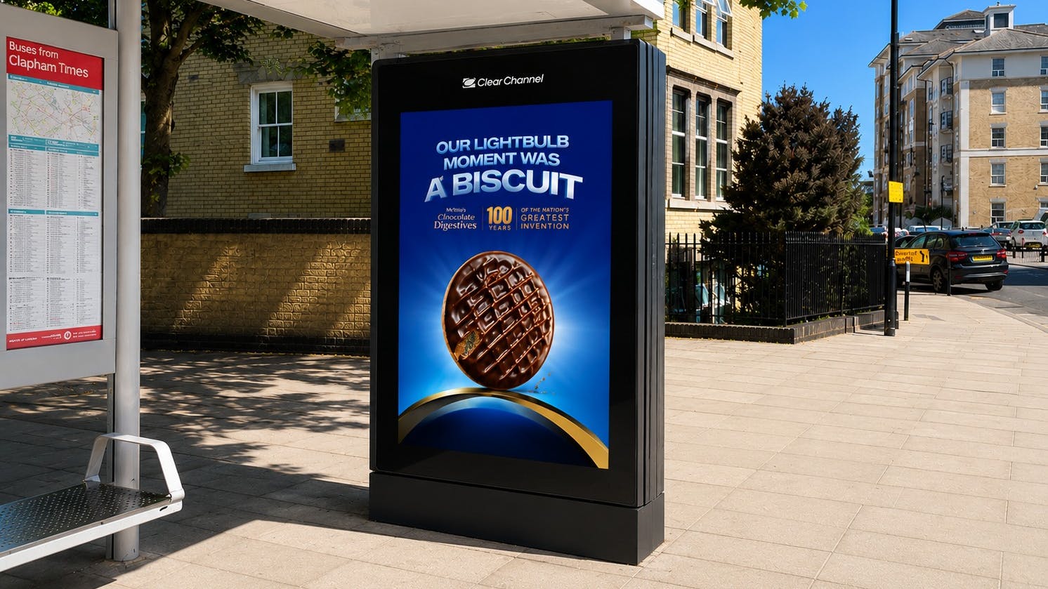 A bus shelter display integrated into the side of the structure displays an ad.