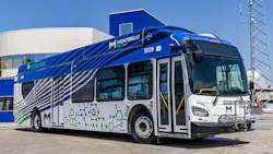 Montebello Bus Lines hydrogen fuel cell bus number 2039 in a bold blue, white, and gray wave livery with molecular chain graphics and a CH2 hydrogen fuel designation on the roof, parked in front of a hydrogen fueling facility on a clear day in Montebello, Calif.