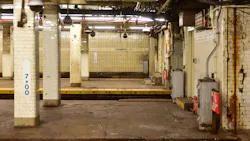 Empty New York City subway platform at the Chambers Street station, with white tile columns, a station wall marked 'Chambers St,' ceiling-mounted security cameras, and visible wear and rust along the walls.