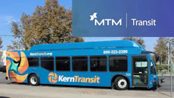 A blue Kern Transit bus parked on a street, featuring a colorful abstract wrap design, the agency's logo and website, and a promotional MTM Transit banner overlaid in the upper right corner.