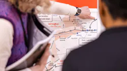 Close-up of two people examining a SEPTA route map showing the Malvern-Great Valley Zone and surrounding communities, with one person pointing to a location near Great Valley Corporate Center.