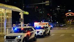 Multiple Transit Police vehicles and an ambulance with emergency lights activated respond to an incident near a station at night, with the illuminated Union Station sign visible in the background.