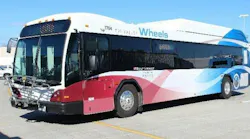 Tri-Valley Wheels bus number 1704 in a white, red and blue wave livery with 'Built Locally' branding and a front-mounted bicycle rack, parked in a transit lot in the Tri-Valley area of California's Alameda County.