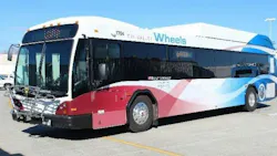 Tri-Valley Wheels bus number 1704 in a white, red and blue wave livery with 'Built Locally' branding and a front-mounted bicycle rack, parked in a transit lot in the Tri-Valley area of California's Alameda County.