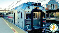 An NJ Transit bi-level rail car, numbered 7011, sits at a platform beside a 'Mind the Gap' warning strip, with the Garden State Initiative logo overlaid in the corner.