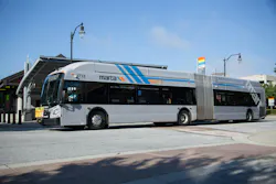 MARTA articulated bus number 1713 in a silver livery with blue and orange diagonal stripes displays Route 39 Buford Highway on its destination board while stopped at Lindbergh Center Transit Station in Atlanta, Georgia, under a clear blue sky.