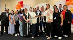 people stand in a line on stage while monica and luz stand in the center holding either end of a baton