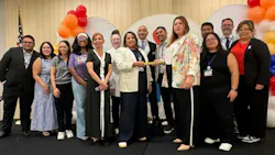 people stand in a line on stage while monica and luz stand in the center holding either end of a baton