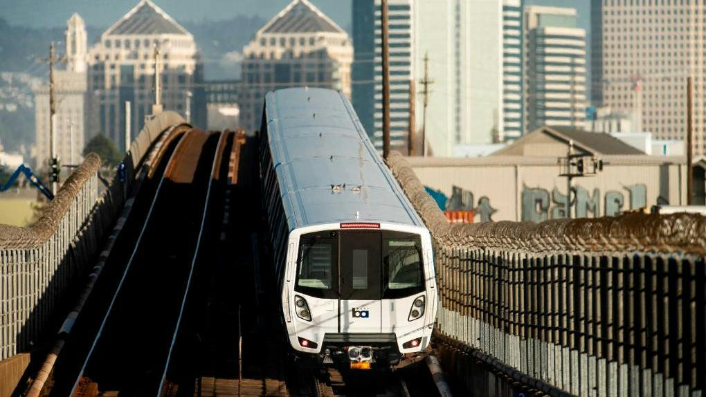 A BART train travels along elevated tracks near downtown Oakland, provided alongside the agency's fiscal year 2026 fourth-quarter rider satisfaction and on-time performance data.