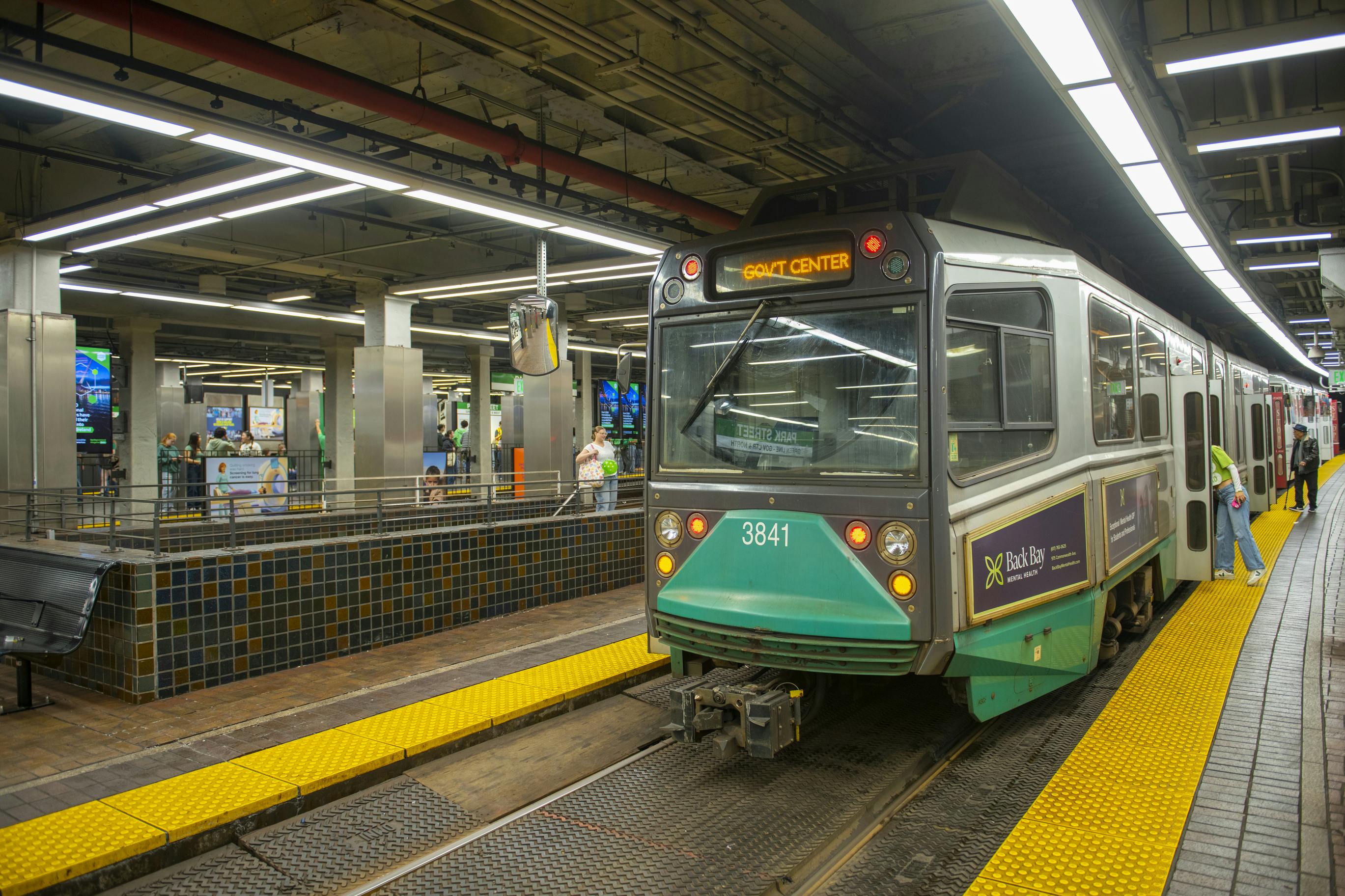 An MBTA Green Line trolley, car 3841, displays 'Gov't Center' as its destination while stopped at Park Street station, with passengers boarding and waiting on the platform.