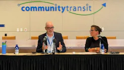 Community Transit CEO Ric Ilgenfritz and Everett Mayor Cassie Franklin speak at a press conference table in front of the Community Transit logo, announcing details of a proposed Interlocal Agreement