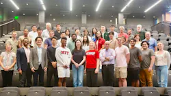 A large group of faculty, researchers and students from the MIT Transit Lab pose together in a lecture hall, with several wearing MIT-branded clothing.