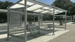 A photo of a new glass-and-steel bus shelter at WMATA's Brookland-CUA station, with digital displays, benches, and the Metro 'M' logo visible, set against a backdrop of trees rendered in color.